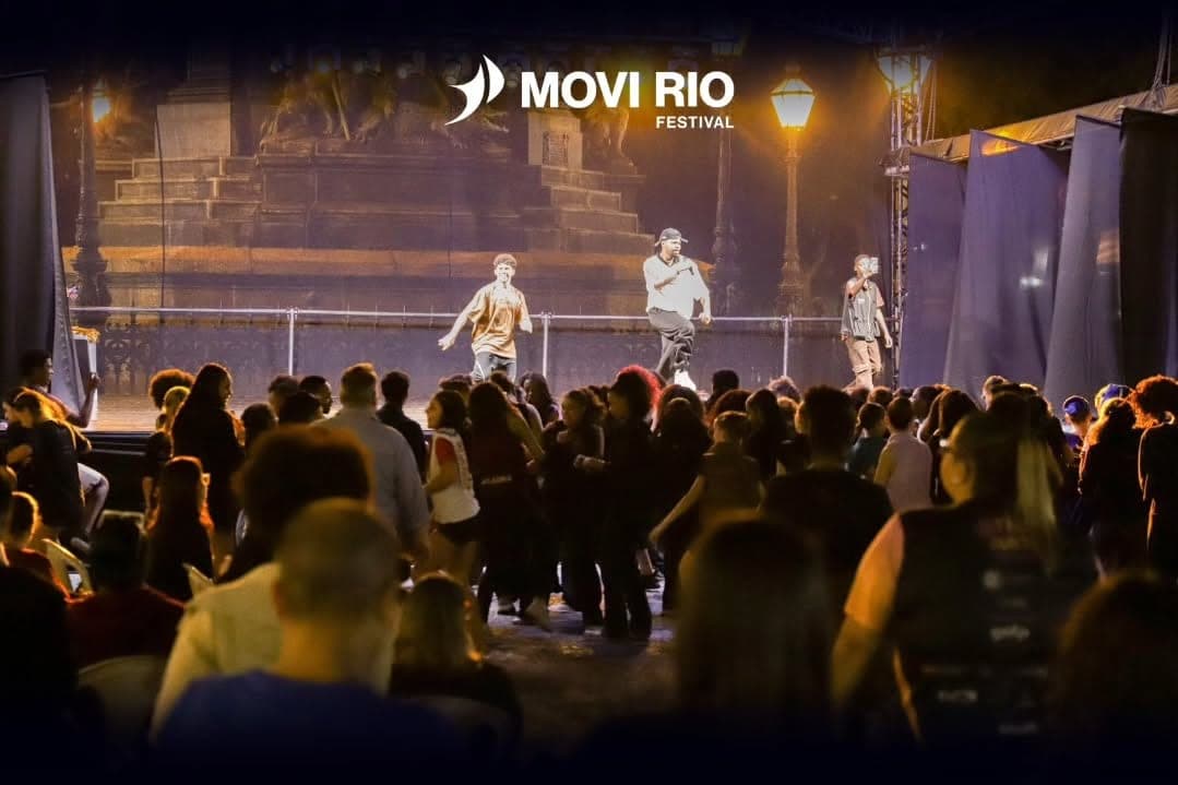 Público assistindo a uma apresentação no Palco Rio, ao ar livre na Praça Tiradentes, à noite
